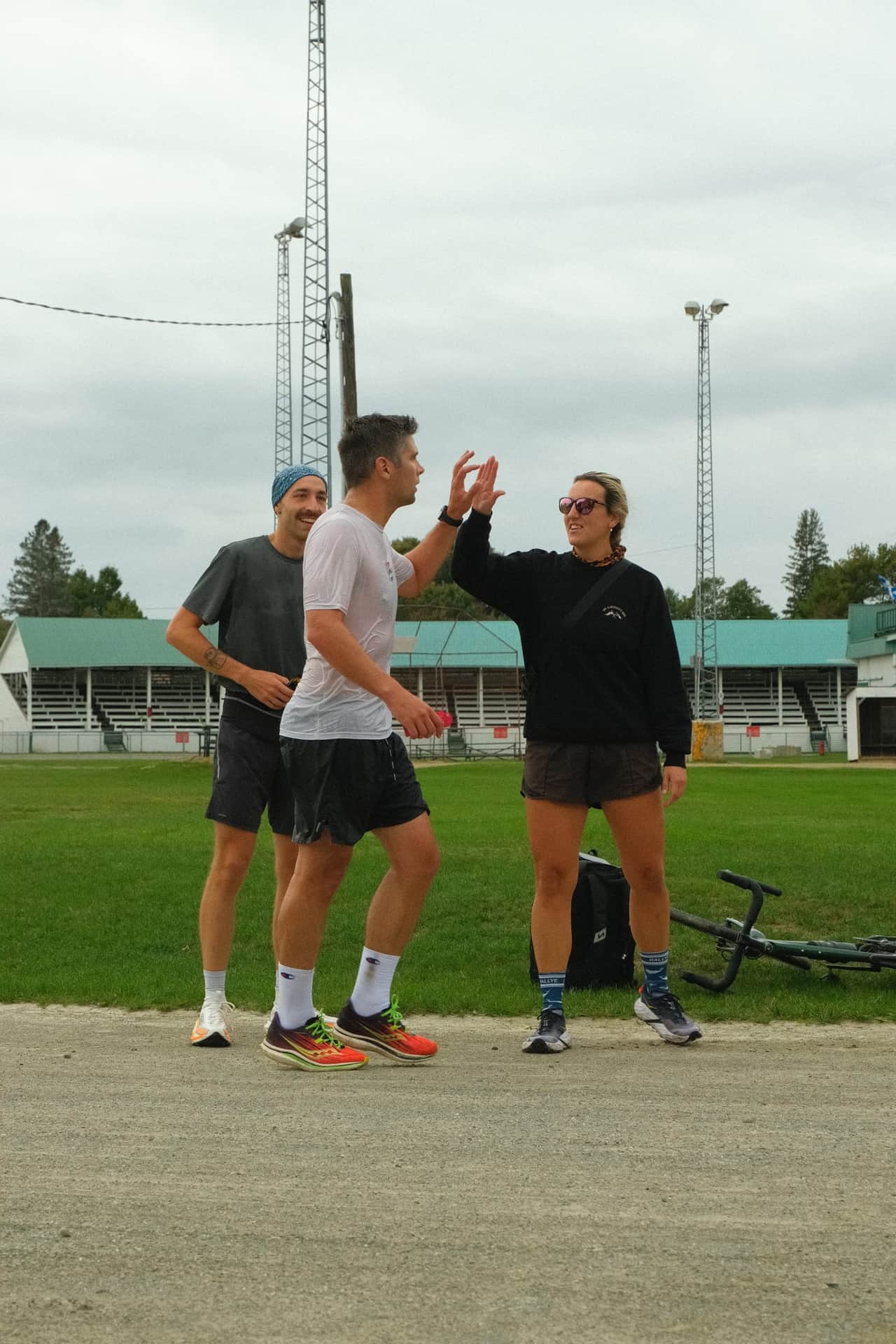 Un coureur échange un high five avec une amie à l'arrivée, devant les estrades.